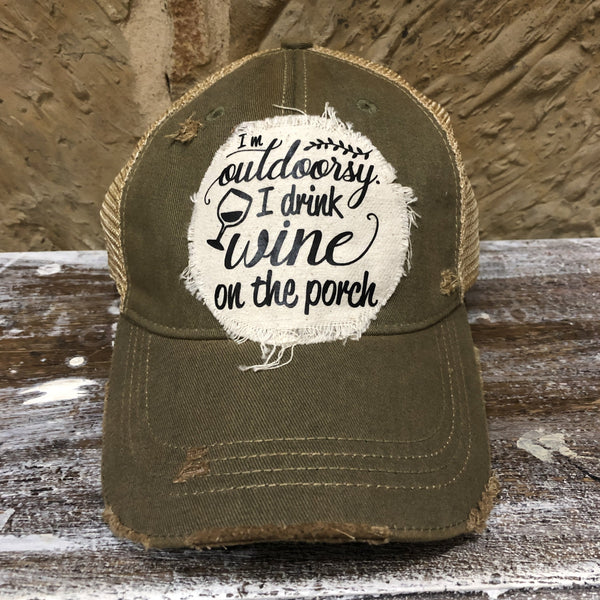 I'm Outdoorsy I Drink Wine on the Porch hat by BohoGroove with black lettering and wine glass graphic on a distressed off-white patch on an olive vintage distressed snapback trucker hat.