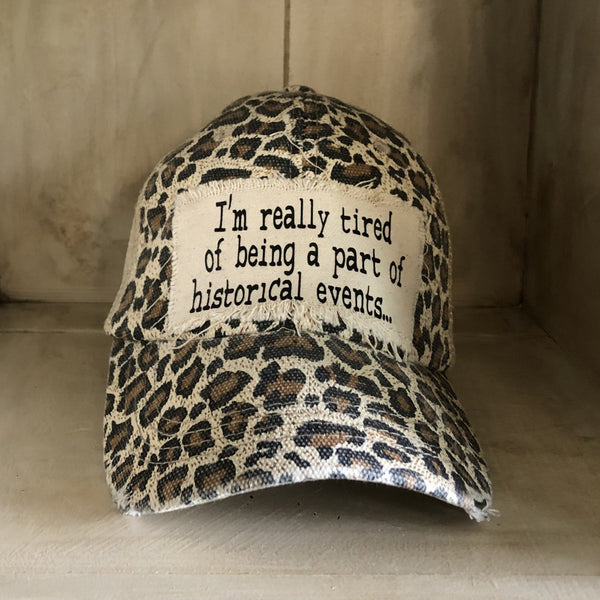 I’m Really Tired of Being Part of Historical Events hat by BohoGroove with black lettering on a distressed off-white patch on a leopard vintage distressed snapback.
