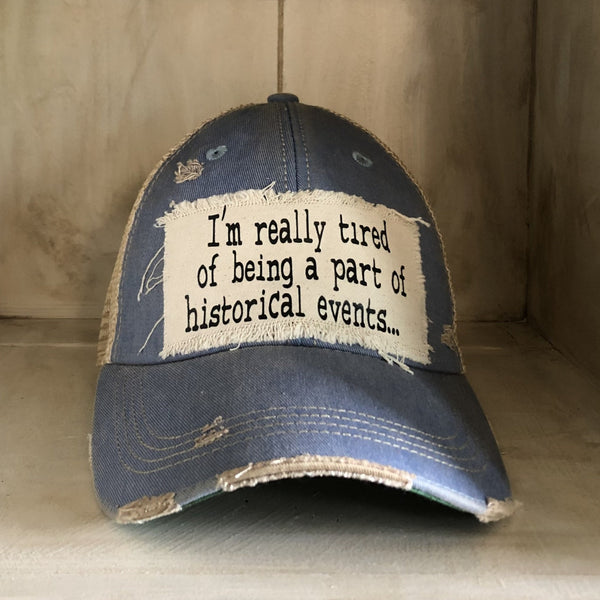 I’m Really Tired of Being Part of Historical Events hat by BohoGroove with black lettering on a distressed off-white patch on a light blue vintage distressed snapback.