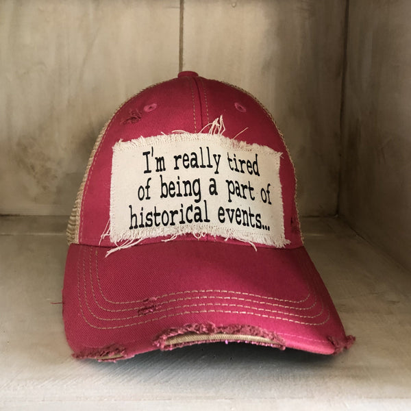 I’m Really Tired of Being Part of Historical Events hat by BohoGroove with black lettering on a distressed off-white patch on a pink vintage distressed snapback.