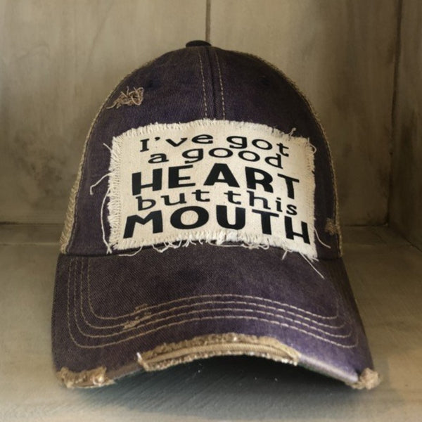 I've Got a Good Heart, but This Mouth hat by BohoGroove with black lettering on a distressed off-white patch on a purple vintage distressed snapback trucker hat.
