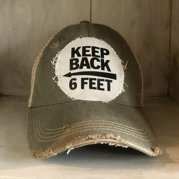 Keep Back 6 Feet hat by BohoGroove with black lettering and arrow graphic on a distressed off-white patch on an ocean blue vintage distressed snapback trucker hat.