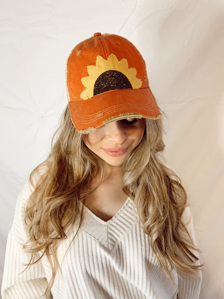 lady wearing bohogroove orange sunflower hat looking down