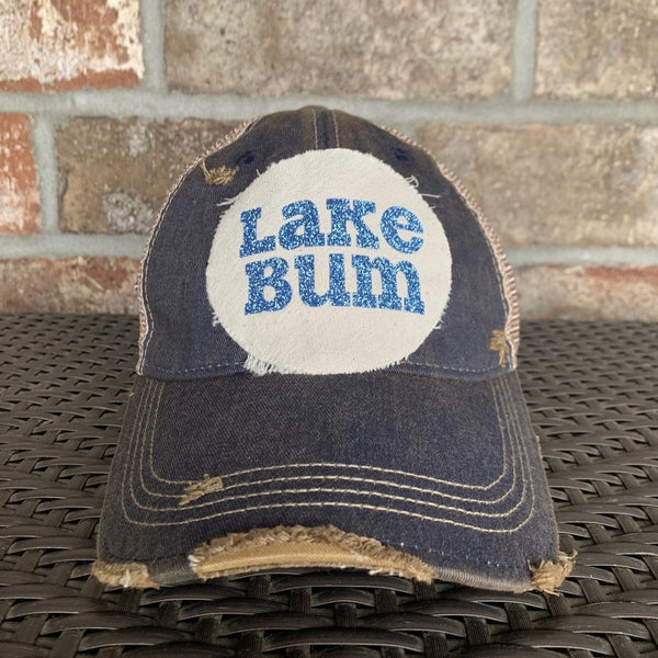 Lake Bum hat by BohoGroove with blue glitter Lake Bum lettering on distressed off-white patch on a navy blue vintage distressed snapback.