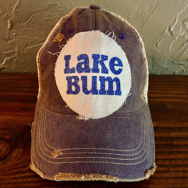 Lake Bum hat by BohoGroove with blue glitter Lake Bum lettering on distressed off-white patch on a purple vintage distressed snapback.
