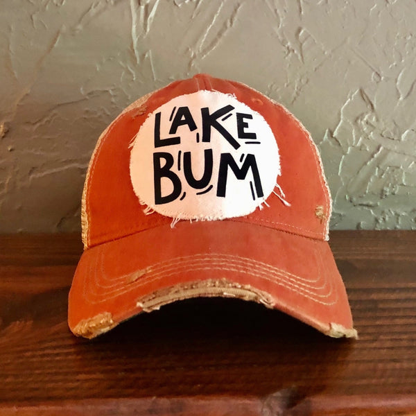 Lake Bum hat by BohoGroove with black Lake Bum lettering on distressed off-white patch on an orange vintage distressed snapback.