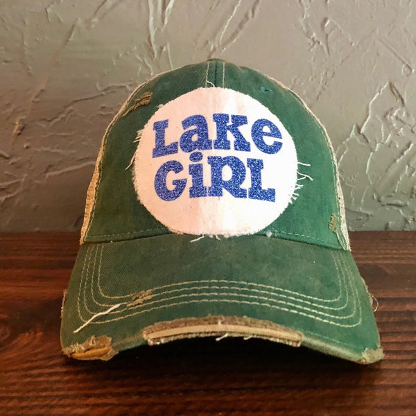 Lake Girl glitter hat by BohoGroove with blue glitter Lake Girl lettering on distressed off-white patch on a green vintage distressed snapback.