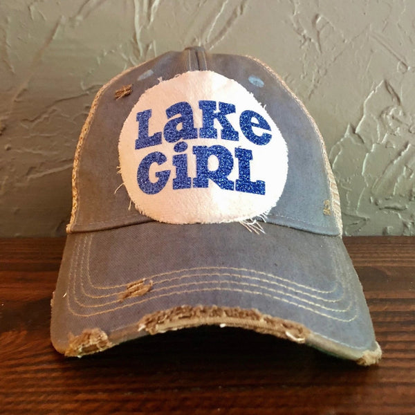 Lake Girl glitter hat by BohoGroove with blue glitter Lake Girl lettering on distressed off-white patch on a light blue vintage distressed snapback.