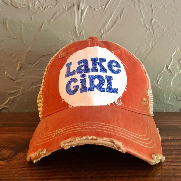 Lake Girl glitter hat by BohoGroove with blue glitter Lake Girl lettering on distressed off-white patch on a red vintage distressed snapback.
