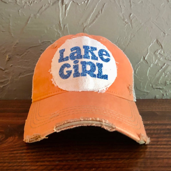 Lake Girl glitter hat by BohoGroove with blue glitter Lake Girl lettering on distressed off-white patch on a sherbet vintage distressed snapback.