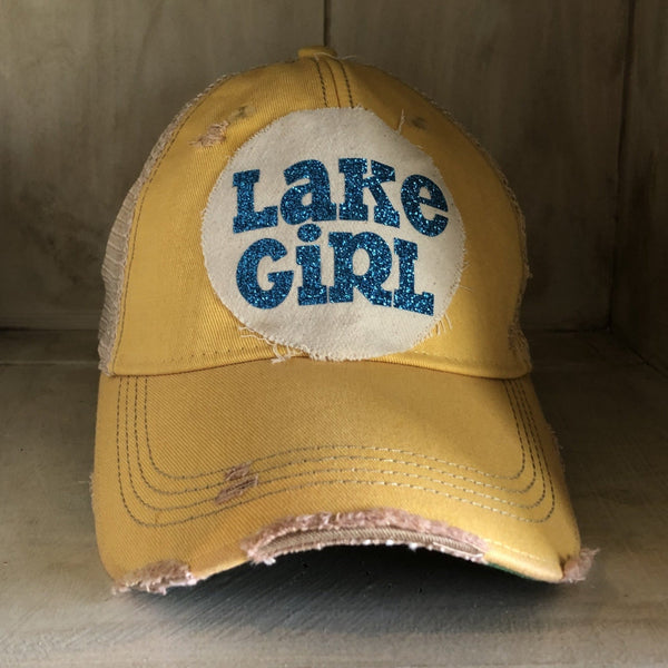 Lake Girl glitter hat by BohoGroove with blue glitter Lake Girl lettering on distressed off-white patch on a yellow vintage distressed snapback.