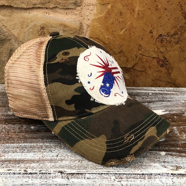 Firework hat by BohoGroove featuring blue glitter firework cannon, red firework burst, and patriotic stars on distressed off-white patch and [color] vintage distressed snapback