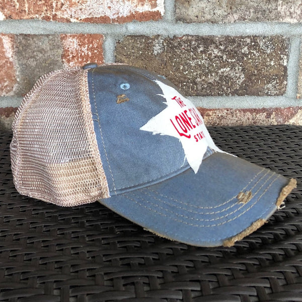 Left side view Lone Star State hat by BohoGroove with red Lone Star State lettering on white star-shaped patch and light blue vintage distressed snapback