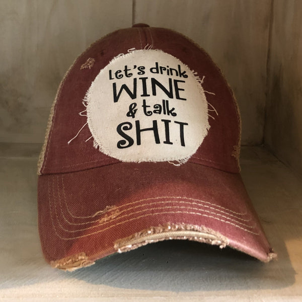 Let’s Drink Wine and Talk Shit hat by BohoGroove with black lettering on a distressed off-white patch on a brick red vintage distressed snapback.