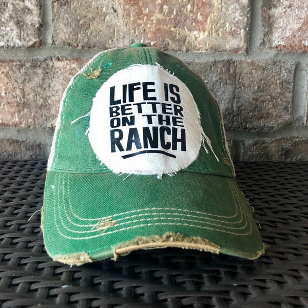 Life Is Better on the Ranch hat by BohoGroove with black Life Is Better on the Ranch lettering on a distressed off-white patch on a green vintage distressed snapback.