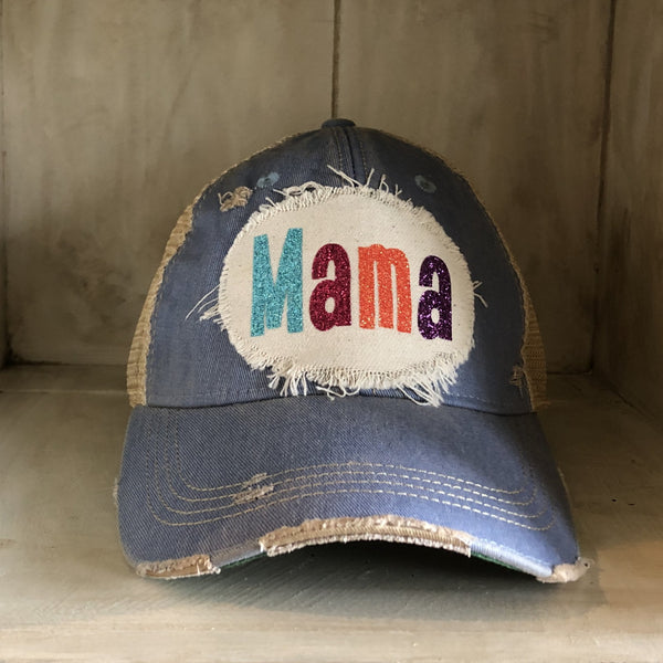 Mama Hat by BohoGroove with turquoise, pink, orange, and purple glitter Mama lettering on distressed off-white patch on a light blue vintage distressed snapback