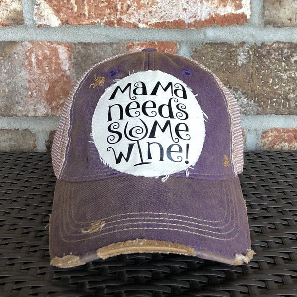 Mama Needs Some Wine hat by BohoGroove featuring whimsical black script lettering on a distressed off-white patch on a purple vintage distressed snapback trucker hat.