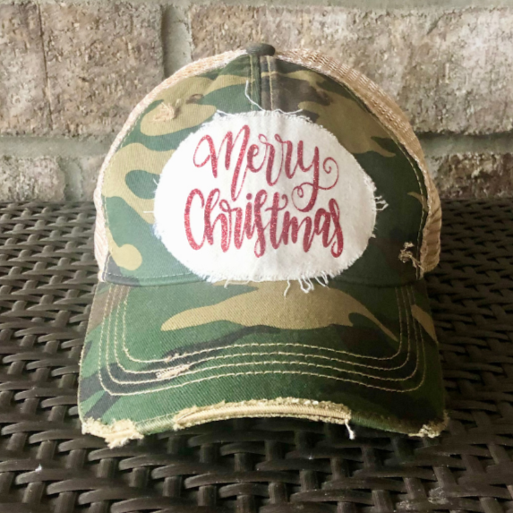 Merry Christmas Glitter hat by BohoGroove with red glitter Merry Christmas script lettering on a distressed off-white custom patch on a camo vintage distressed snapback.
