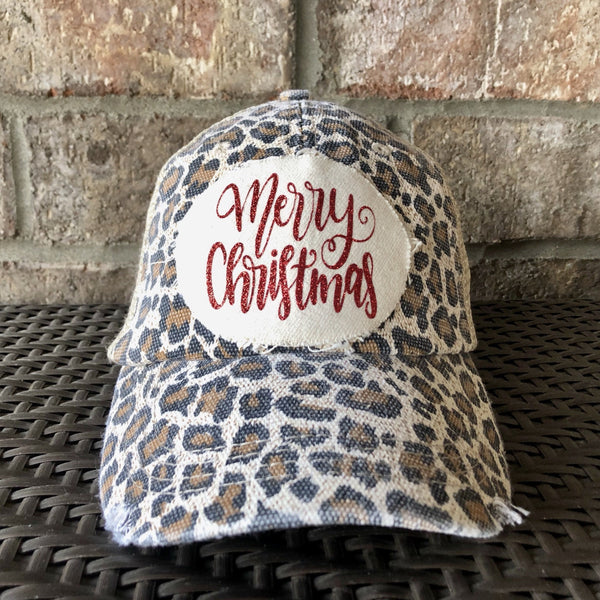 Merry Christmas Glitter hat by BohoGroove with red glitter Merry Christmas script lettering on a distressed off-white custom patch on a leopard vintage distressed snapback.