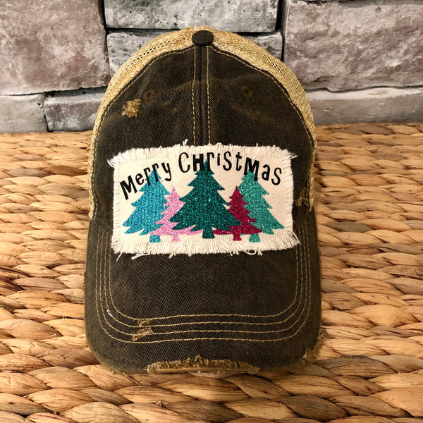 Merry Christmas hat by BohoGroove with black Merry Christmas lettering and five glitter Christmas trees in turquoise, pink, dark green, red, and mint on a distressed off-white patch on a black vintage distressed snapback.