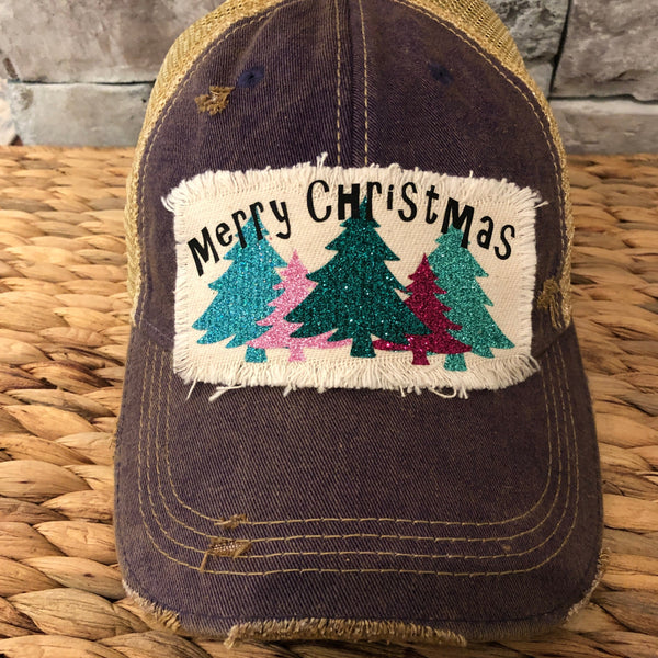 Merry Christmas hat by BohoGroove with black Merry Christmas lettering and five glitter Christmas trees in turquoise, pink, dark green, red, and mint on a distressed off-white patch on a purple vintage distressed snapback.