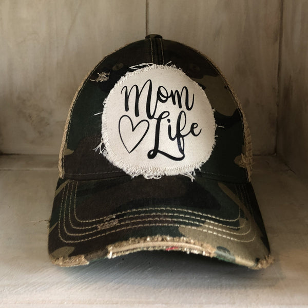 Mom Life hat by BohoGroove with black Mom Life lettering and heart graphic on a distressed off-white patch on a camo vintage distressed snapback.