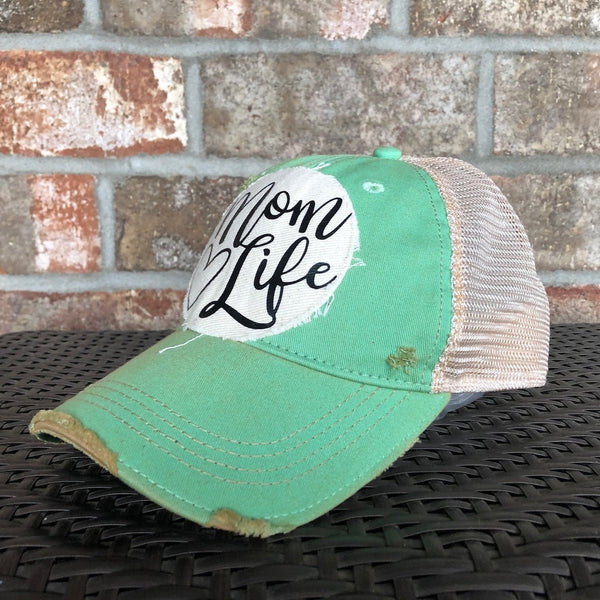 Right side view of the Mom Life hat by BohoGroove featuring black Mom Life lettering and heart graphic on a distressed off-white patch on a mint vintage distressed snapback.