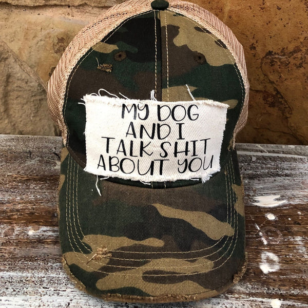 My Dog and I Talk Shit About You hat by BohoGroove with black My Dog and I Talk Shit About You lettering on a distressed off-white patch on a camo vintage distressed snapback.