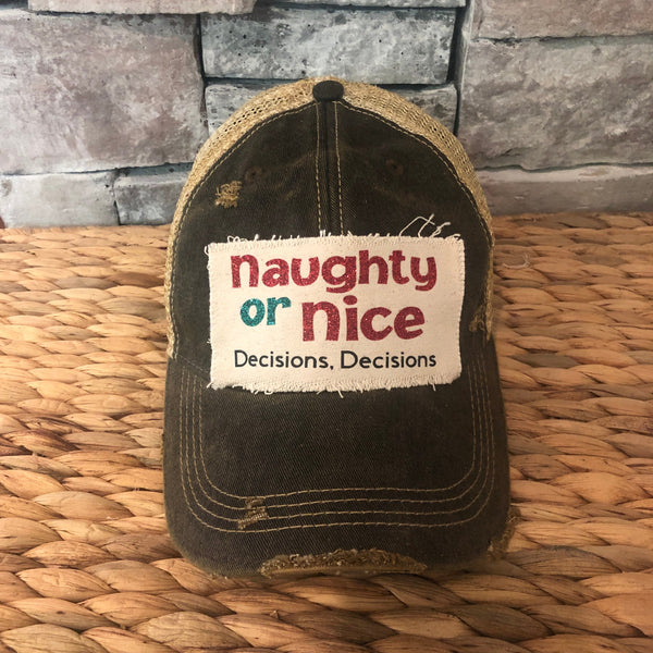 Naughty or Nice hat by BohoGroove with red and green Naughty or Nice lettering and Decisions, Decisions wording on a distressed off-white patch on a black vintage distressed snapback.