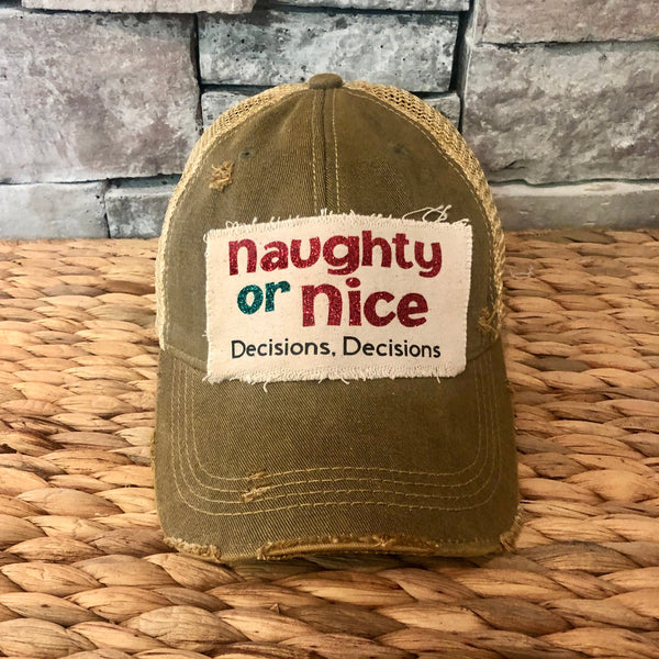 Naughty or Nice hat by BohoGroove with red and green Naughty or Nice lettering and Decisions, Decisions wording on a distressed off-white patch on an olive vintage distressed snapback.