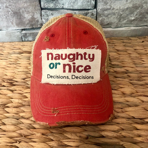 Naughty or Nice hat by BohoGroove with red and green Naughty or Nice lettering and Decisions, Decisions wording on a distressed off-white patch on a red vintage distressed snapback.