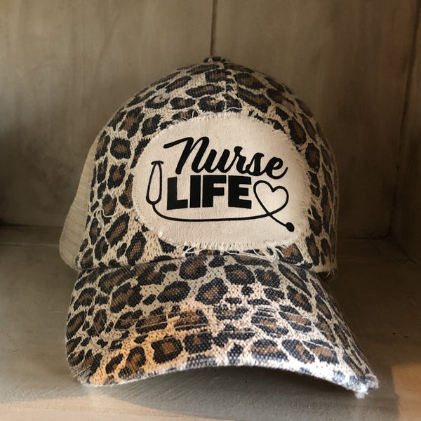 Nurse Life hat by BohoGroove with black Nurse Life lettering, stethoscope graphic, and heart detail on a distressed off-white patch on a leopard vintage distressed snapback.
