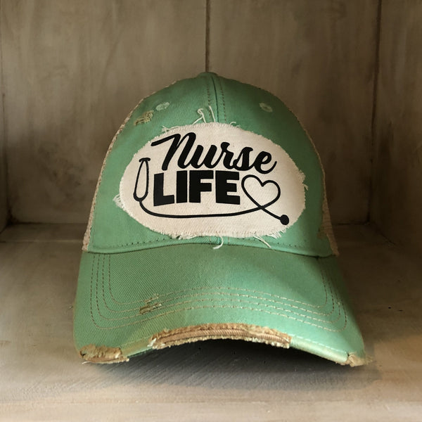Nurse Life hat by BohoGroove with black Nurse Life lettering, stethoscope graphic, and heart detail on a distressed off-white patch on a mint vintage distressed snapback.
