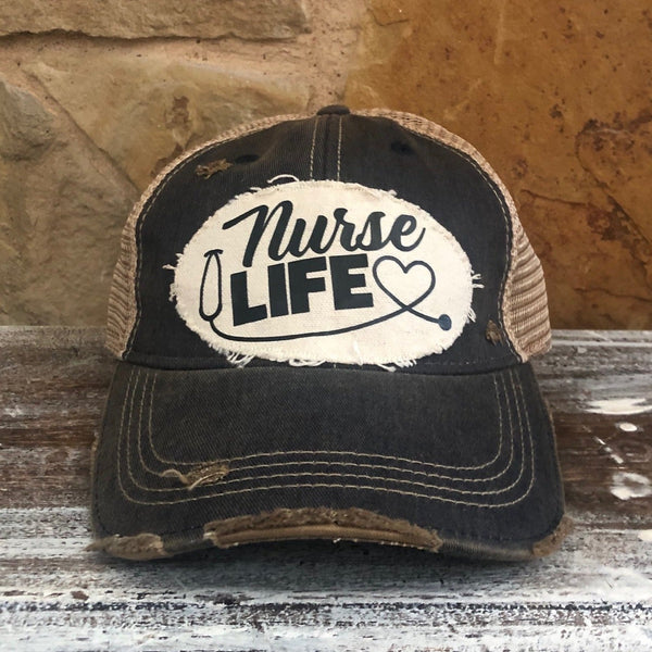 Nurse Life hat by BohoGroove with black Nurse Life lettering, stethoscope graphic, and heart detail on a distressed off-white patch on a navy vintage distressed snapback.