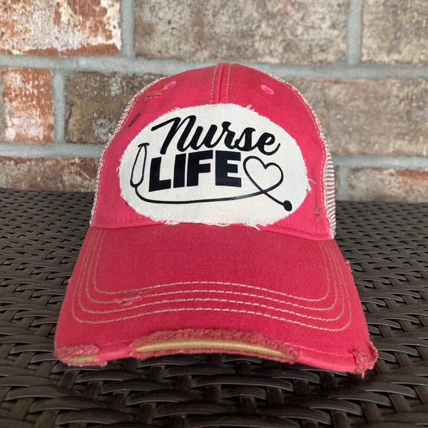 Nurse Life hat by BohoGroove with black Nurse Life lettering, stethoscope graphic, and heart detail on a distressed off-white patch on a pink vintage distressed snapback.