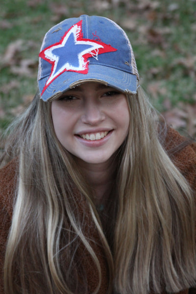 Blue distressed snapback hat featuring a patriotic red white and blue star patch worn by model