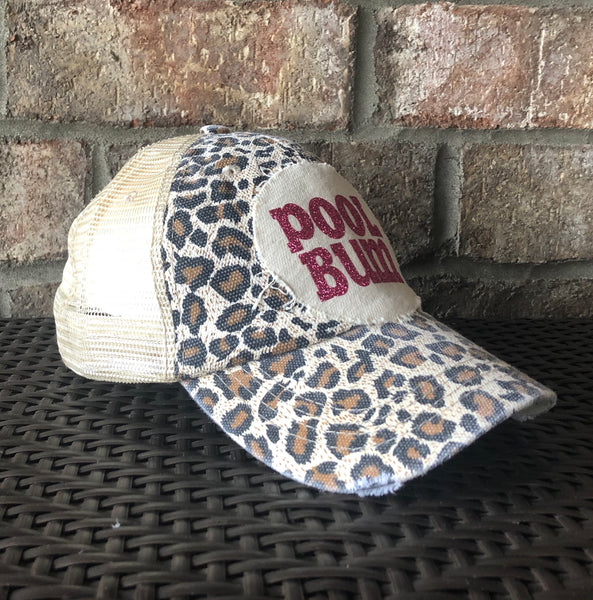 Pool Bum hat by BohoGroove featuring distressed off-white patch with pink glitter Pool Bum lettering on a leopard vintage distressed snapback left side