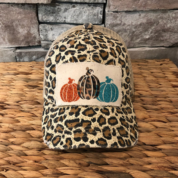 Pumpkin hat by BohoGroove featuring orange, leopard, and turquoise glitter pumpkin graphics on a cream patch on a leopard vintage distressed snapback.
