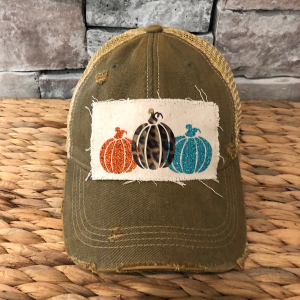 Pumpkin hat by BohoGroove featuring orange, leopard, and turquoise glitter pumpkin graphics on a cream patch on an olive vintage distressed snapback.