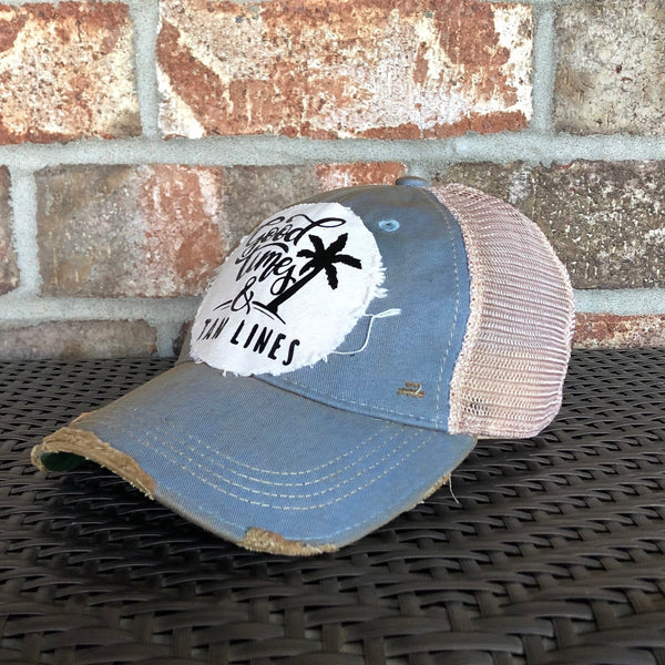 Good Times & Tan Lines hat by BohoGroove with black lettering and palm tree graphic on distressed off-white patch on light blue vintage distressed snapback.