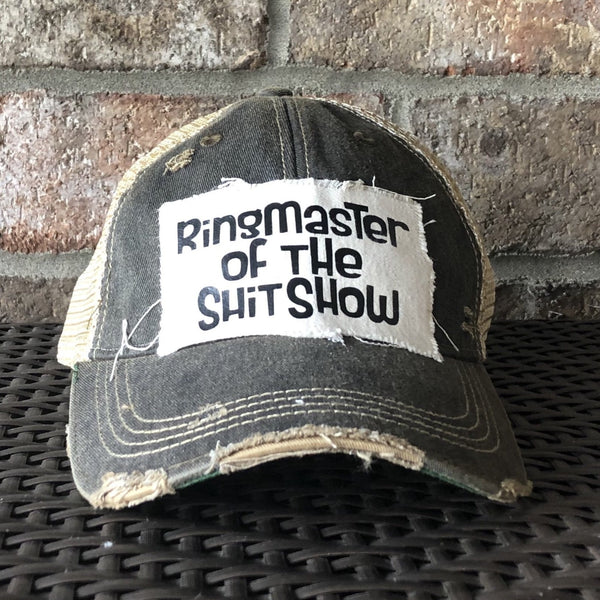 Ringmaster of the Shit Show hat by BohoGroove with black Ringmaster of the Shit Show lettering on a distressed off-white patch on a black vintage distressed snapback trucker hat.