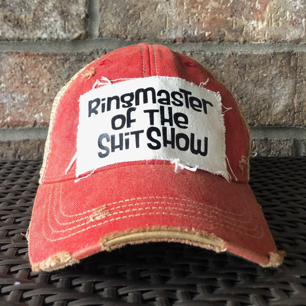 Ringmaster of the Shit Show hat by BohoGroove with black Ringmaster of the Shit Show lettering on a distressed off-white patch on a red vintage distressed snapback trucker hat.