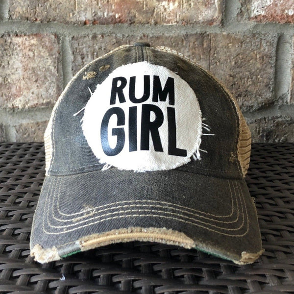 Rum Girl hat by BohoGroove with bold black Rum Girl lettering on a distressed off-white patch on a black vintage distressed snapback trucker hat.