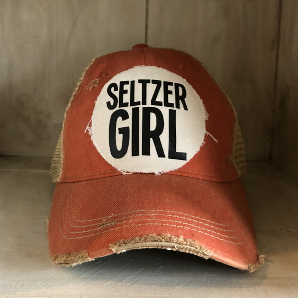 Seltzer Girl hat by BohoGroove with black lettering on a distressed off-white patch on a orange vintage distressed snapback trucker hat.