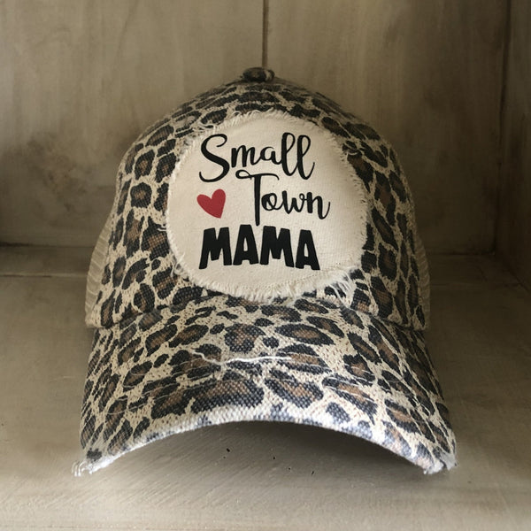 Small Town Mama hat by BohoGroove with black Small Town Mama lettering and red heart graphic on a distressed off-white patch on a leopard vintage distressed snapback.