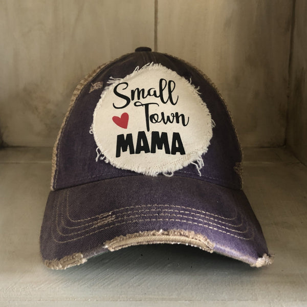 Small Town Mama hat by BohoGroove with black Small Town Mama lettering and red heart graphic on a distressed off-white patch on a purple vintage distressed snapback.