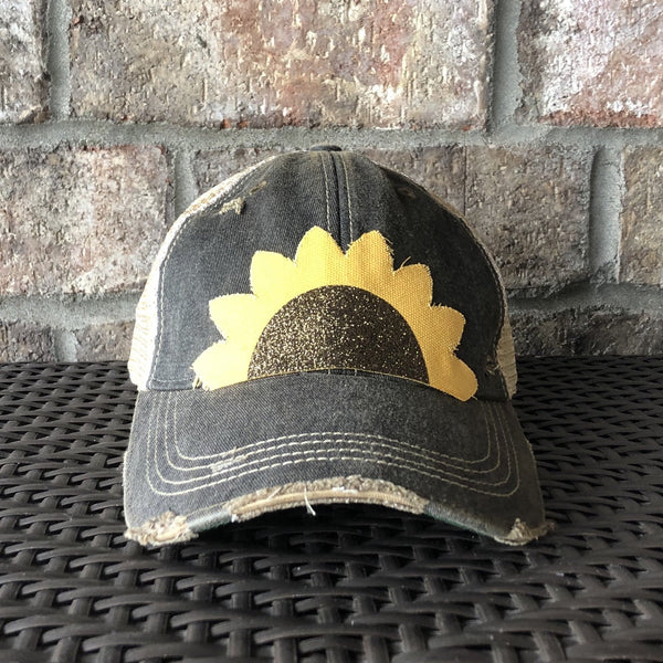 Sunflower hat by BohoGroove with yellow sunflower petals and a black glitter sunflower center on a black vintage distressed snapback.