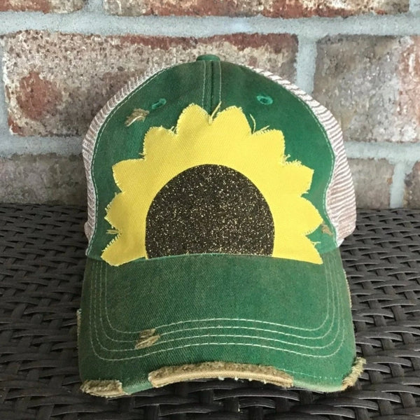Sunflower hat by BohoGroove with yellow sunflower petals and a black glitter sunflower center on a green vintage distressed snapback.
