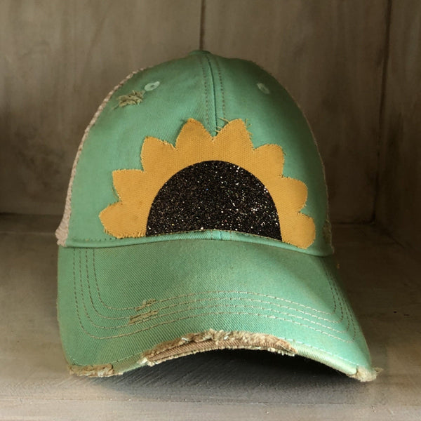 Sunflower hat by BohoGroove with yellow sunflower petals and a black glitter sunflower center on a mint vintage distressed snapback.