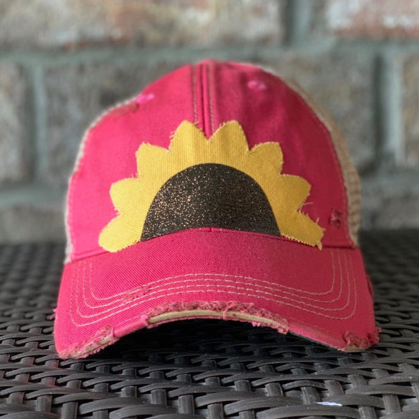 Sunflower hat by BohoGroove with yellow sunflower petals and a black glitter sunflower center on a pink vintage distressed snapback.